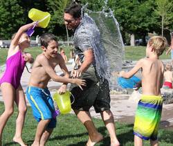 Quelle: pixabay.de / rudyanderson, https://pixabay.com/de/photos/wasserkampf-kinder-wasser-spielen-442257/ Kinder spritzen Erwachsenen nass